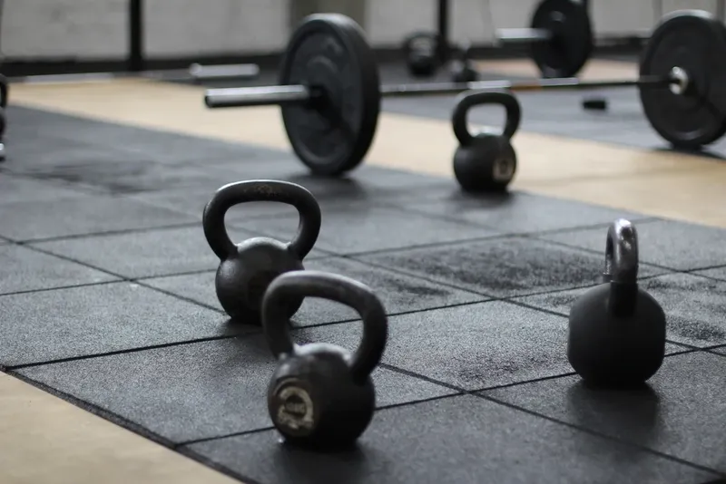Kettlebells and barbells on a gym floor