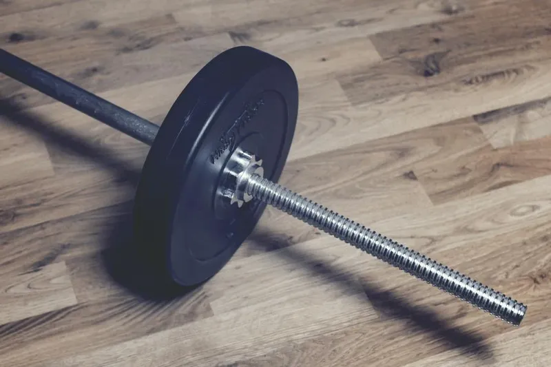 A barbell lying on a wooden floor